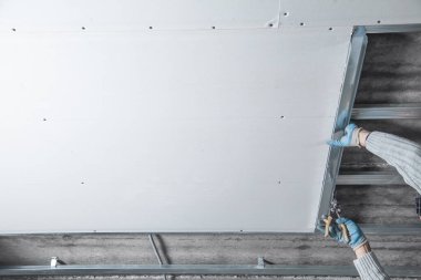 Bir tavan inşaatının metal profiliyle çalışmak.