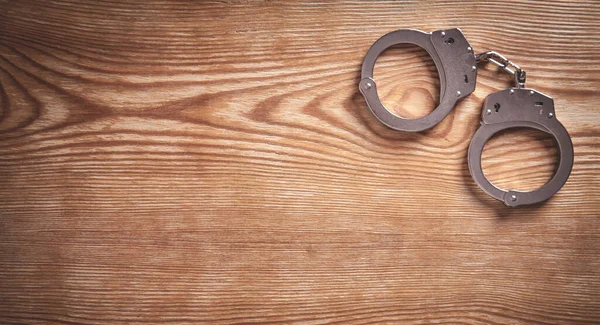 Metal Handcuffs Wooden Background — Stock Photo, Image