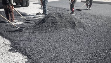 Asfalt düzenleyen işçiler. Yol yapımı. Sanayi