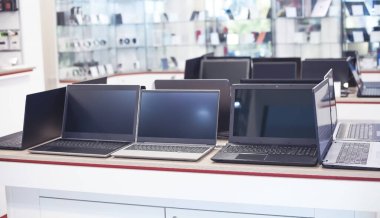 Elektronik mağazasındaki masada dizüstü bilgisayarlar var..