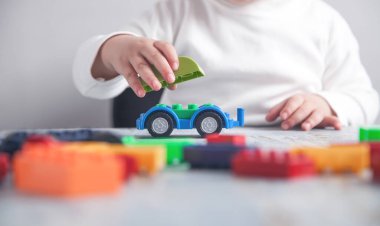 Küçük kız oyuncak arabayla oynuyor..