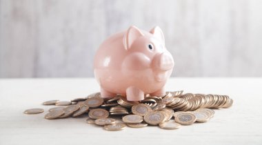 Masasında bozuk paralar olan bir kumbara. Para biriktiriliyor