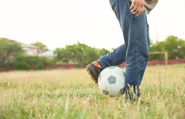 Futbol sahasında futbol topu olan beyaz bir çocuk..