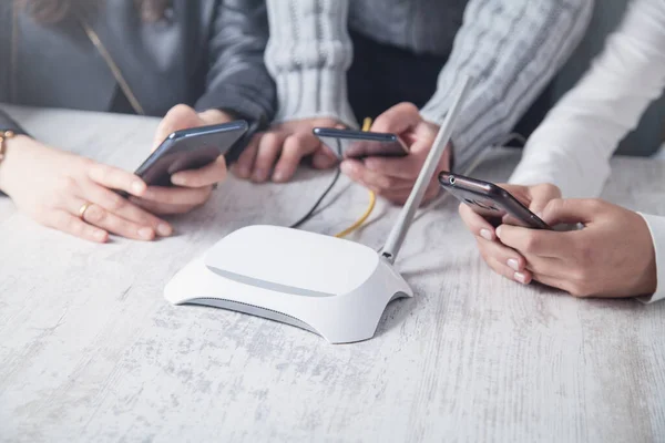 Internet router in the desk. People using smartphones