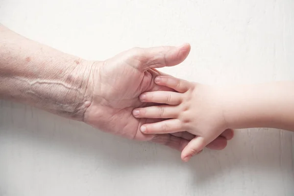 高齢者の女性と子供の手を一緒に — ストック写真