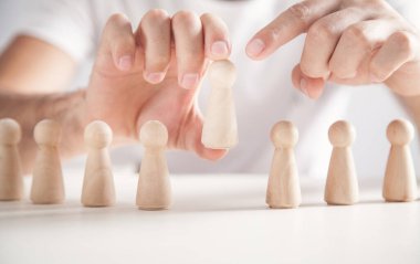 Tahta insan figürü tutan bir adam. Lider