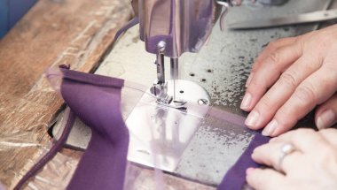 Dikiş makinesiyle çalışan terzi..