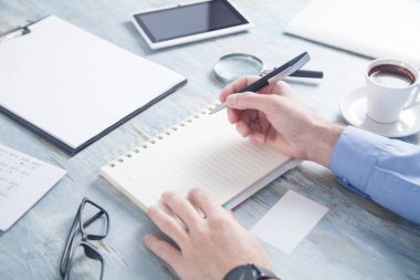 Business desk içindeki bir not defteri yazma işadamı.