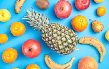 Mavi arka planda ananas, muz, nar..