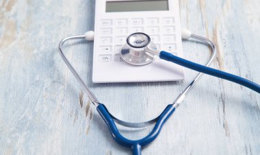 Masasında steteskop olan hesap makinesi..