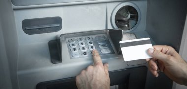 Kredi kartı olan bir adamın eli. ATM 'de. Parayı çek.