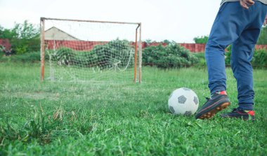 Futbol sahasında futbol topu olan beyaz bir çocuk..