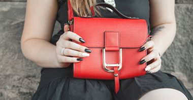 Kırmızı deri çanta tutan kadın. Moda.