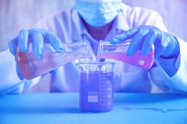 Laboratuvarda şişelerle çalışan bir kız..