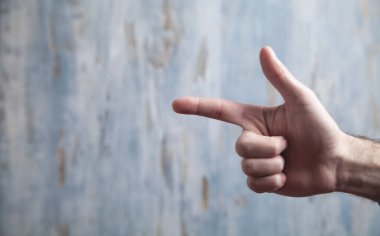 Mavi ahşap arka planda bir erkek parmağı var..