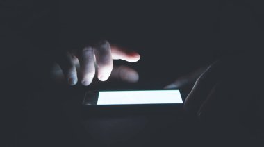 Geceleri akıllı telefon kullanan bir adam. Teknoloji. İş dünyası
