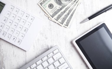 Bilgisayar klavyesi, tableti ve hesap makinesi olan 100 dolarlık banknotlar..