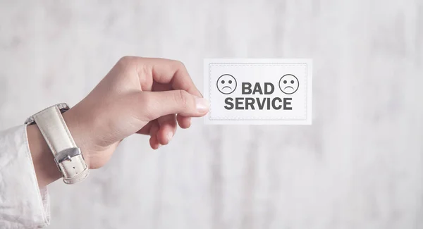 Hand showing Bad Service in business card.