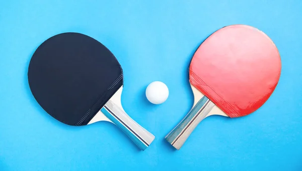 テーブルテニスラケットと青い背景の白いプラスチックボール — ストック写真
