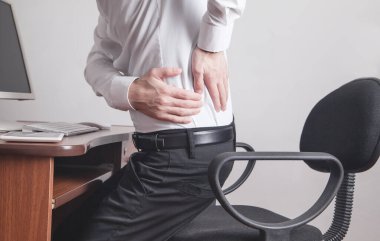 Beyaz iş adamı ofiste sırt ağrısı çekiyor..