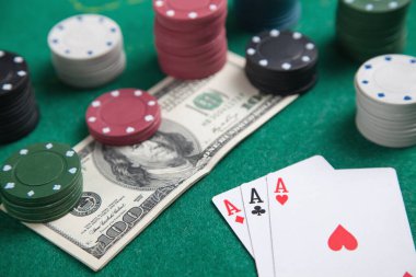 Kumarhane fişleri, kartlar ve para yeşil masada..