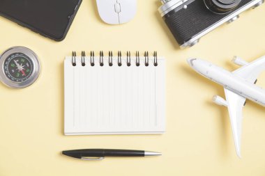 Sarı arkaplanda pusula ve diğer nesneler var. Seyahat