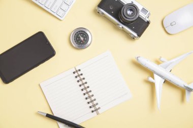 Sarı arkaplanda pusula ve diğer nesneler var. Seyahat