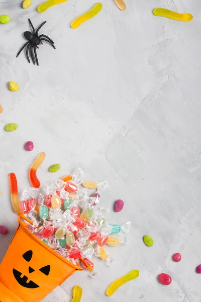 Halloween orange bucket with candies, jujubes, and rubber spider — ストック写真