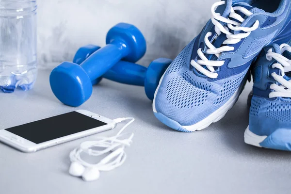 Sport shoes, dumbbells, mobile phone, earphones and bottle of wa — Stockfoto