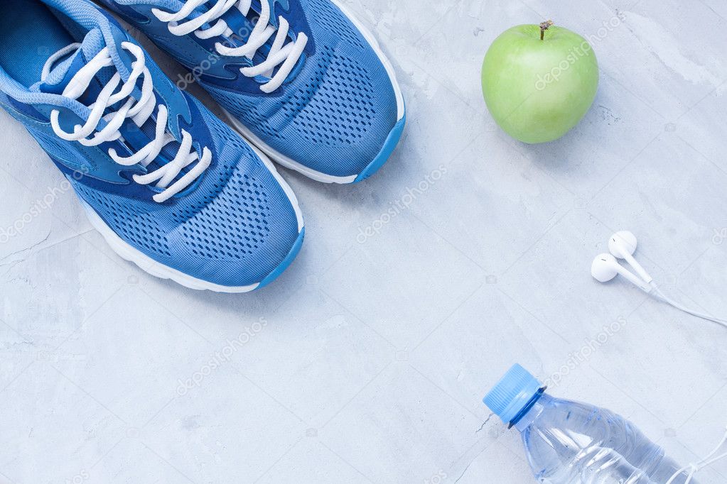 Flat lay sport shoes, bottle of water and earphones