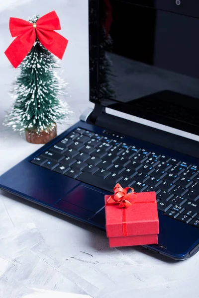 Laptop, pequena árvore de Natal e caixa de presente vermelho — Fotografia de Stock