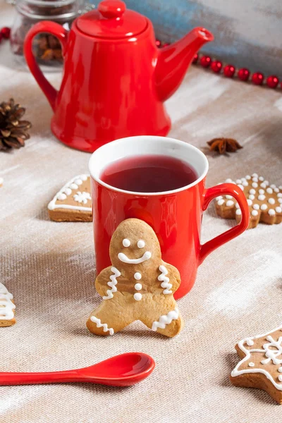 Chá, biscoito de gengibre e colher vermelha no fundo de madeira compensada — Fotografia de Stock
