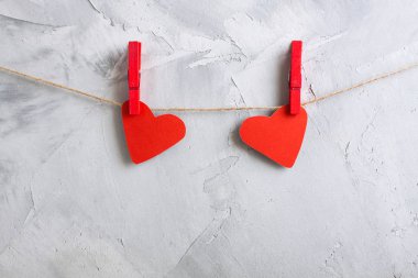 Bir ip üzerinde clothespins üzerine asılı iki kırmızı kağıt kalp.