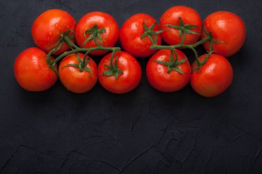 Siyah beton zemin üzerine kırmızı taze organik domates