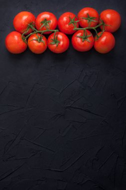 Siyah beton zemin üzerine kırmızı taze organik domates