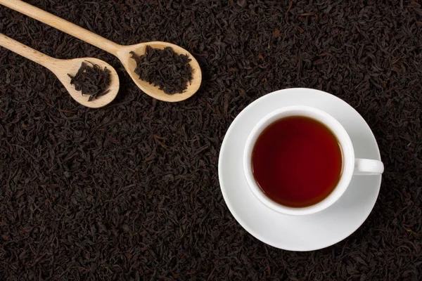 Doku arka plan tahta kaşıklar Kupası kuru siyah çay yaprakları.