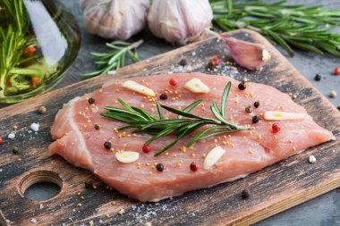 Ahşap tahta üzerinde malzemelerle çiğ domuz eti et parçası