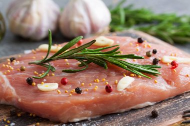 Ahşap tahta üzerinde malzemelerle çiğ domuz eti et parçası