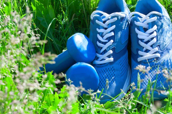 Summer sports composition with blue sneakers and dumbbells