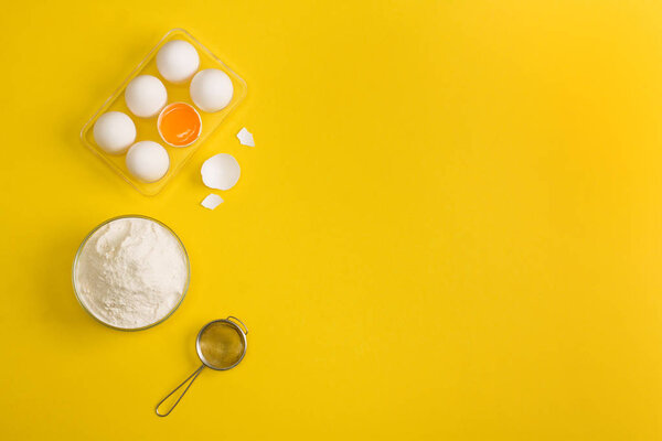 Выпечка плоский отложен фон с яйцом пол сита на желтый
