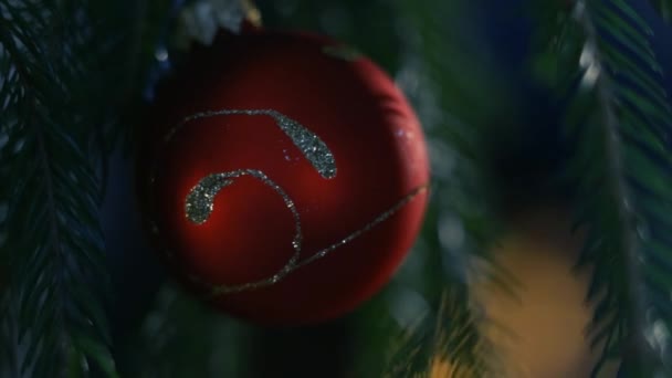 Rode bal op groene kerstboom — Stockvideo