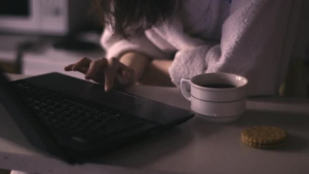 Жінка використовує ноутбук і п'є каву — стокове відео