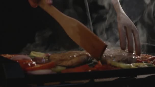 Chef flips pieces of meat — Stock Video