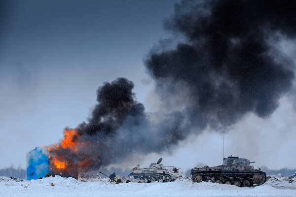 Winter view of the german tanks (panzers) with burning house in the battle. 