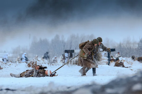 Red Army medics in action with the injured soldier in the battle. — Stock Photo, Image