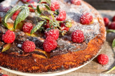 Ahududu ve ahşap arka plan üzerinde toz ile pasta. Rustik tarzı. 