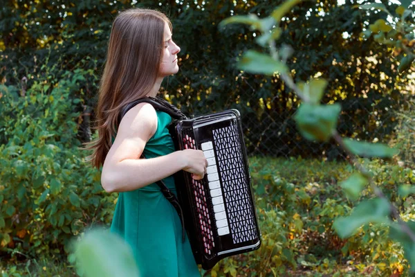 Музикант дівчина грає на російський баян (кнопковий акордеон) і спів. — стокове фото