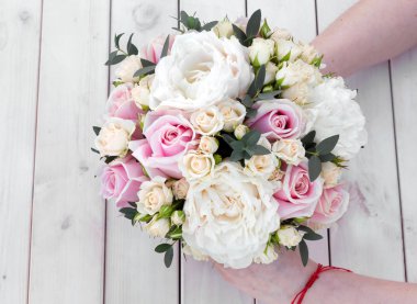 Beyaz ahşap zemin üzerinde farklı çiçekler gelin buketi.