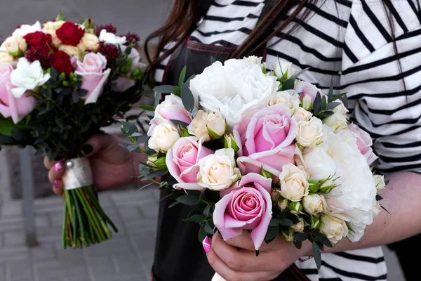 Two bouquets for bride in florist hands.