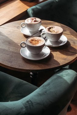 Kafedeki masada büyük beyaz bardakta kakao. Şekerleme, biber ve tarçınlı kakao..